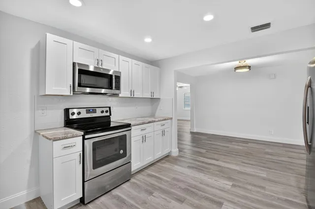a kitchen with a sink a stove and microwave