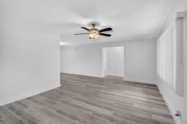 a view of empty room with wooden floor