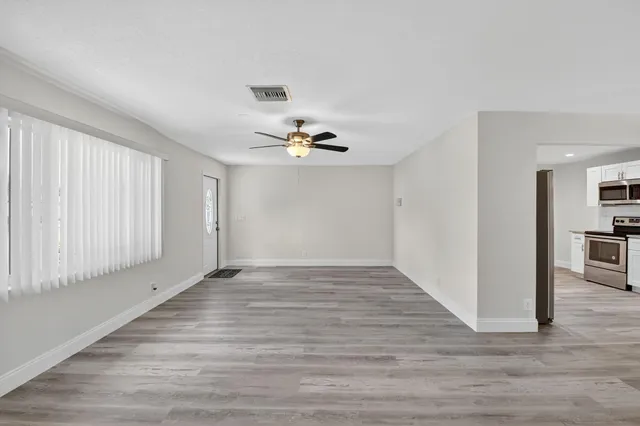 a view of a livingroom with wooden floor and a ceiling fan