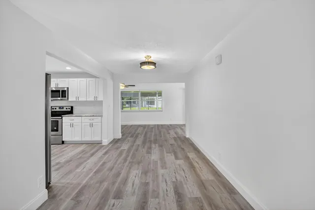 a view of kitchen with wooden floor electronic appliances and window