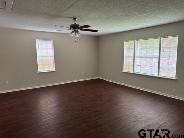 2611 South Boldt Avenue Tyler, TX 75701 - Photo 3 of 14 an empty room with wooden floor chandelier fan and windows
