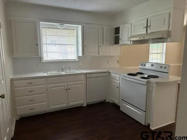 a kitchen with cabinets appliances a sink and a window