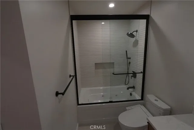 a bathroom with a granite countertop toilet and a shower