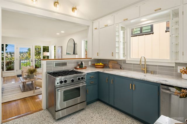 a kitchen with stainless steel appliances granite countertop a stove sink and cabinets