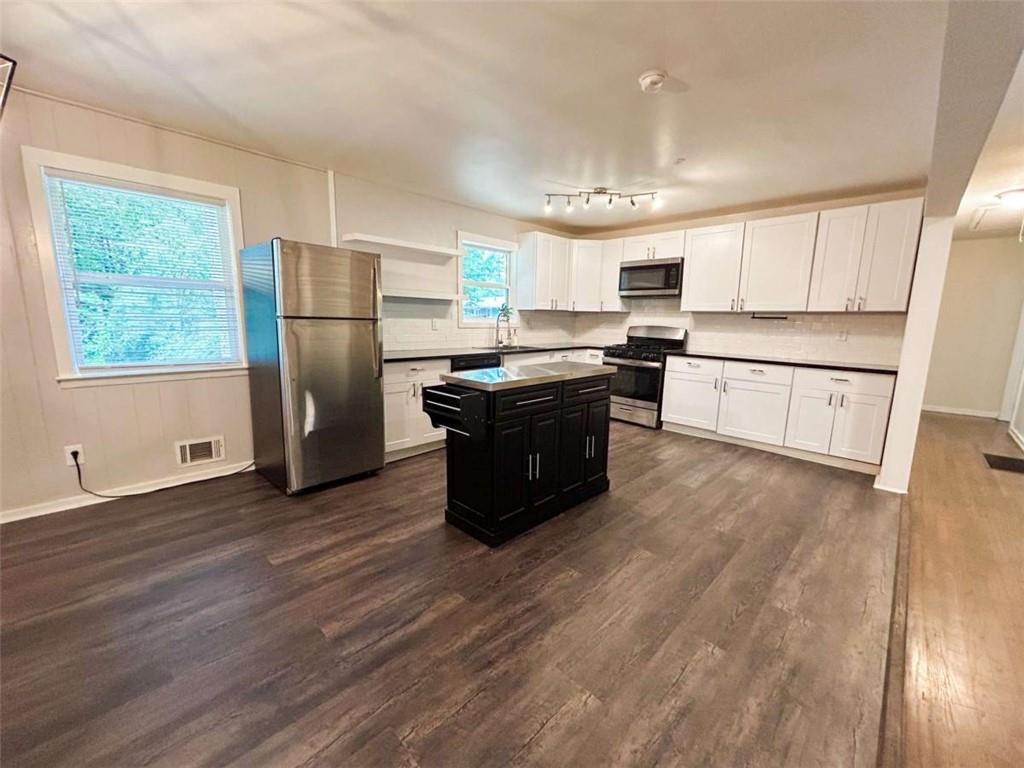 811 Cinderella Way Decatur, GA 30033 - Photo 6 of 33 a kitchen with stainless steel appliances granite countertop a refrigerator a sink dishwasher a stove and white countertops with wooden floor