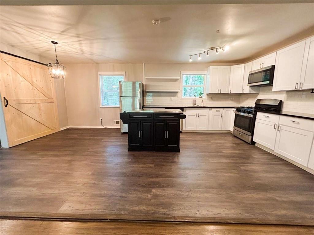 811 Cinderella Way Decatur, GA 30033 - Photo 7 of 33 a large kitchen with kitchen island a stove a sink a refrigerator and white cabinets