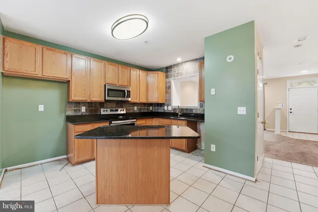 a kitchen with stainless steel appliances granite countertop a refrigerator and a stove top oven