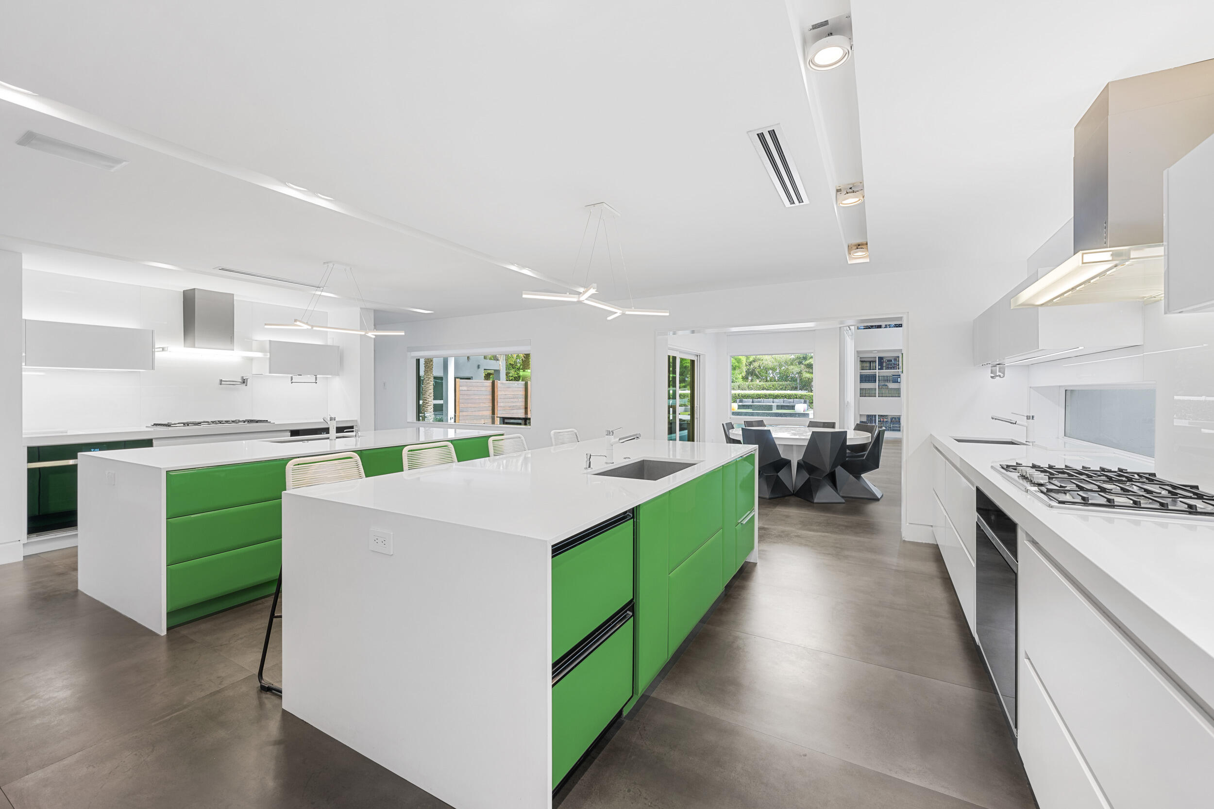 7047 San Sebastian Circle Boca Raton, FL 33433 - Photo 23 of 95 a large kitchen with kitchen island a stove a sink a refrigerator and a dining table with wooden floor
