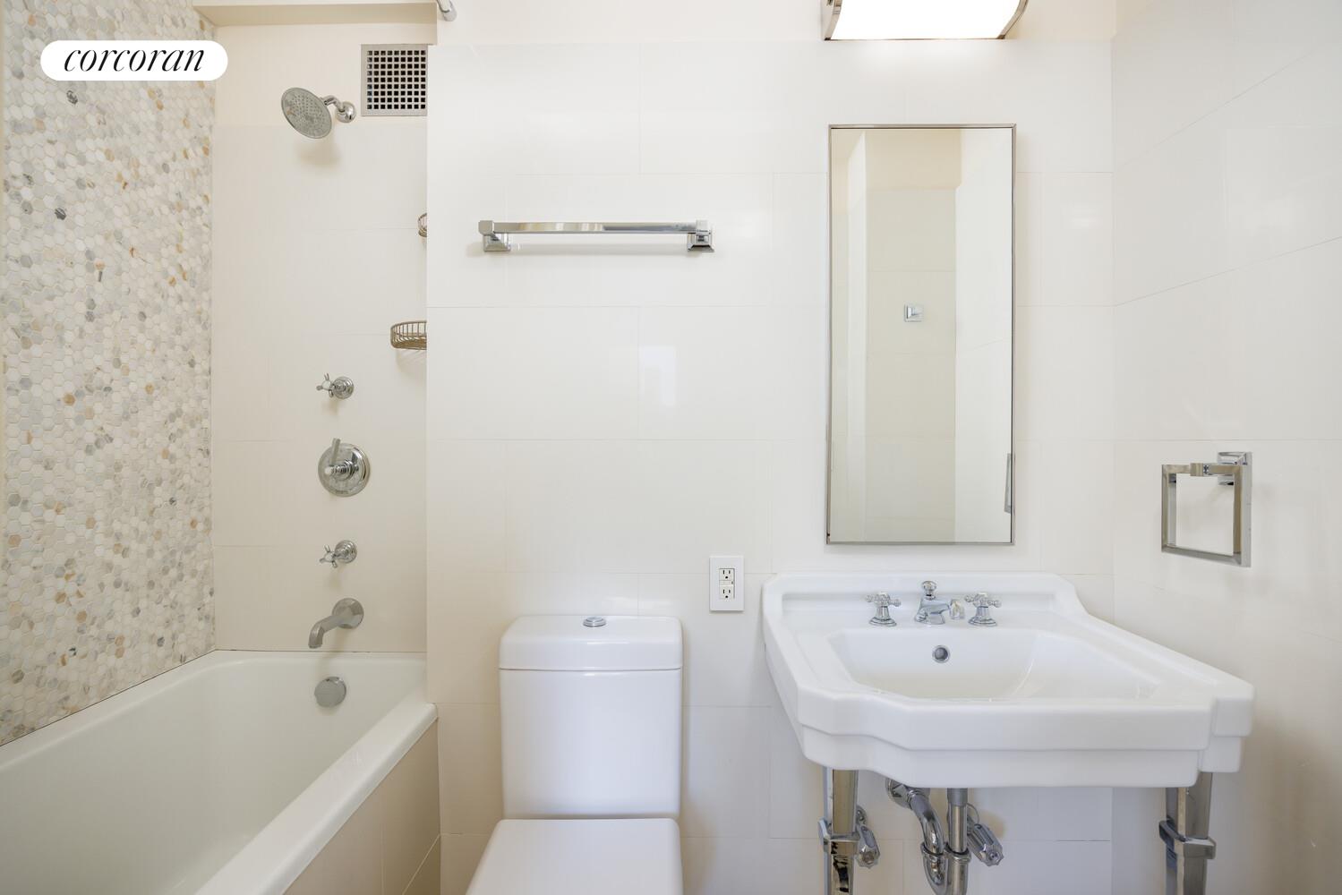 870 5th Avenue, Unit 10/11B Manhattan, NY 10065 - Photo 11 of 14 a bathroom with a sink a mirror and a bathtub