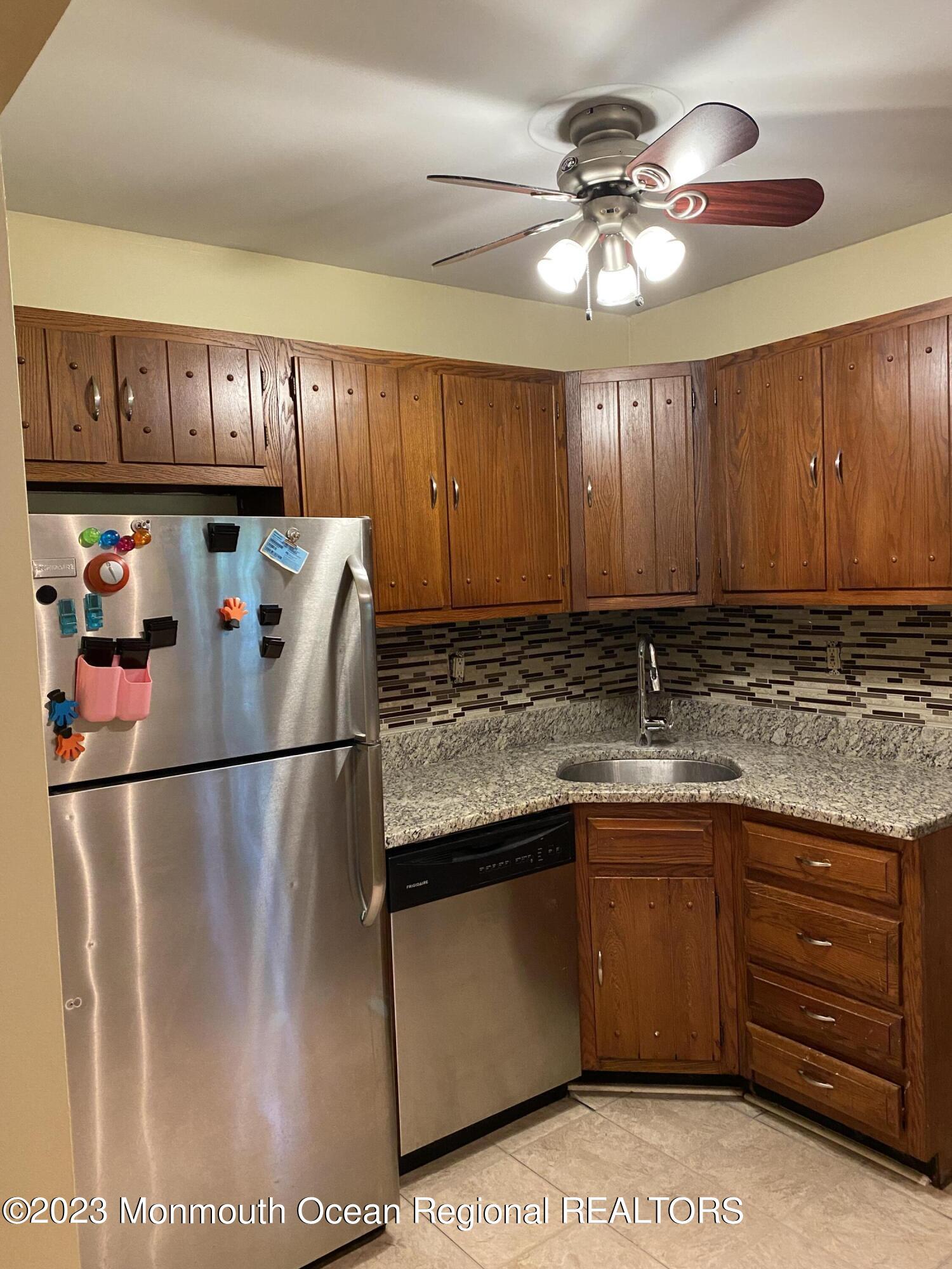 91 Arrowood Road, Unit E Manalapan, NJ 07726 - Photo 7 of 8 a kitchen with a sink and cabinets
