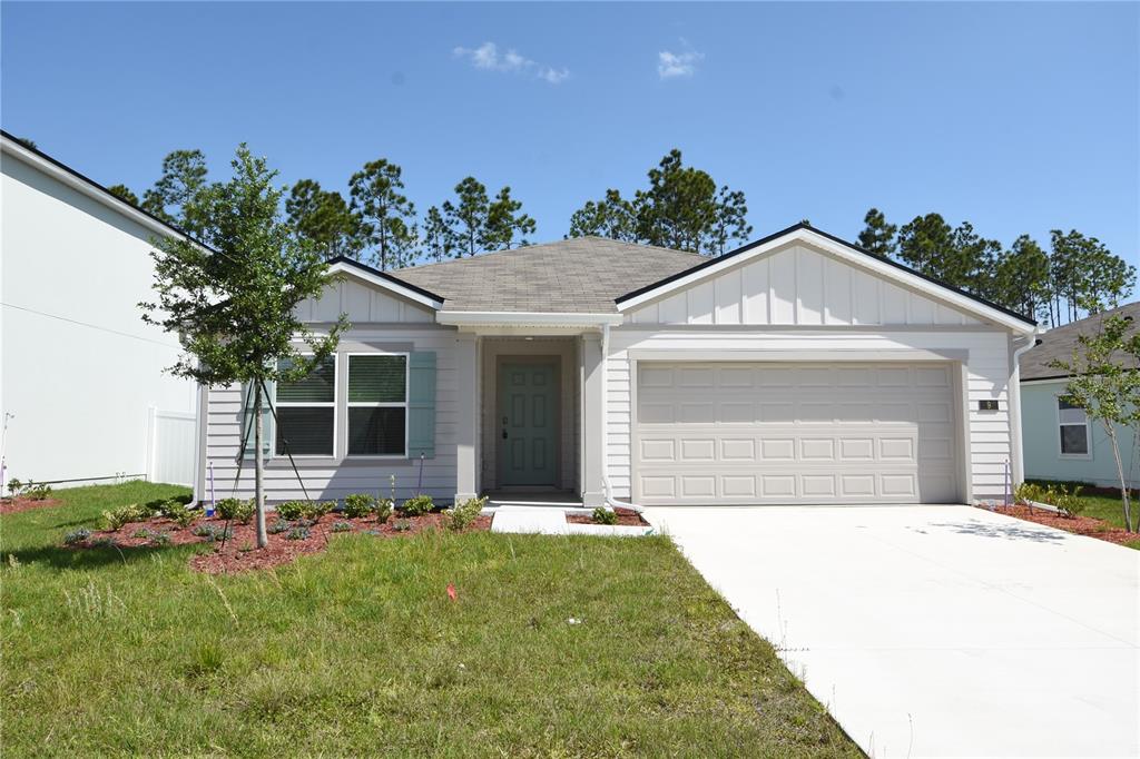 9 Springwood Drive Palm Coast, FL 32137 - Photo 1 of 29 a front view of a house with a yard and potted plants