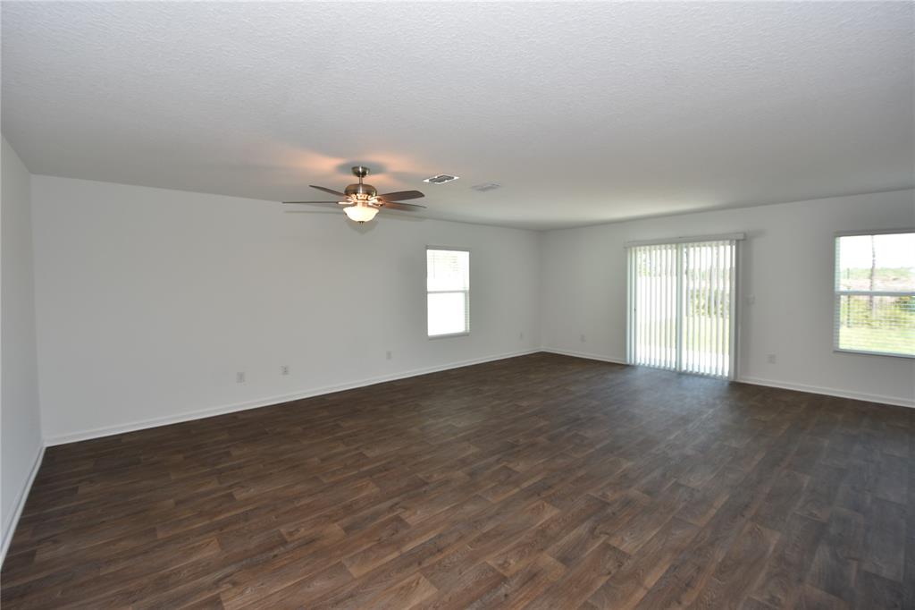 9 Springwood Drive Palm Coast, FL 32137 - Photo 11 of 29 wooden floor in an empty room with a window