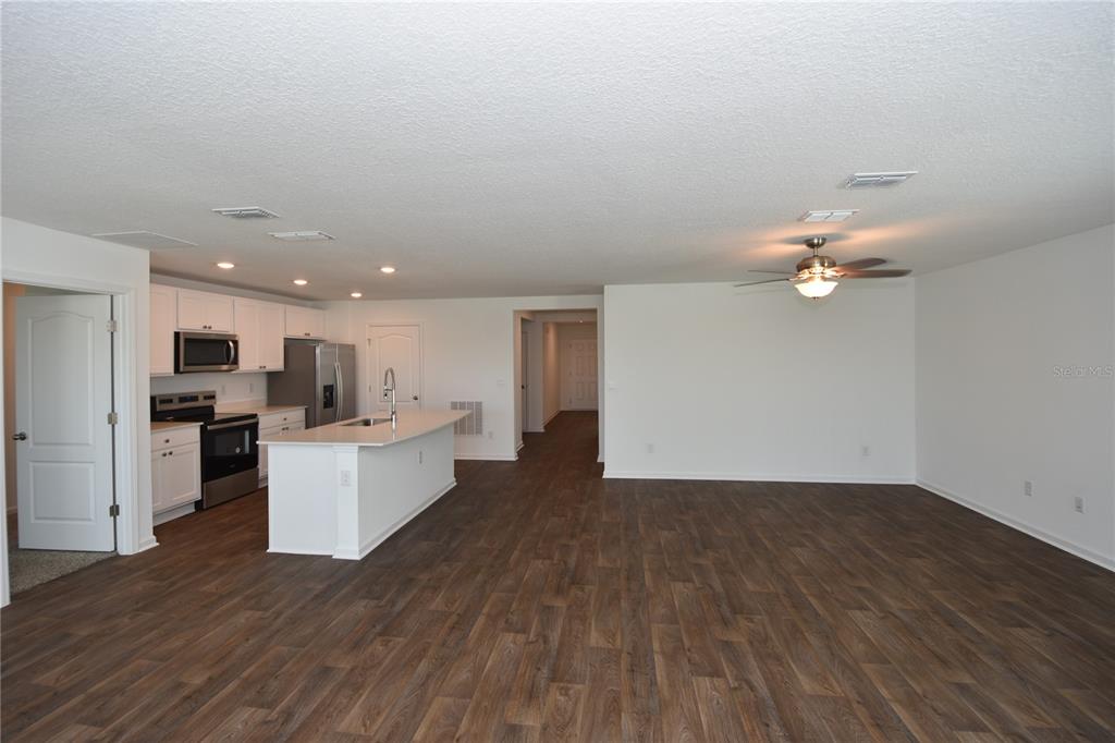 9 Springwood Drive Palm Coast, FL 32137 - Photo 13 of 29 a living room with kitchen island furniture and a kitchen view