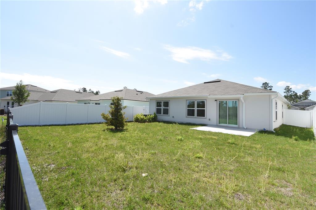 9 Springwood Drive Palm Coast, FL 32137 - Photo 2 of 29 a yellow house with garden in front of it