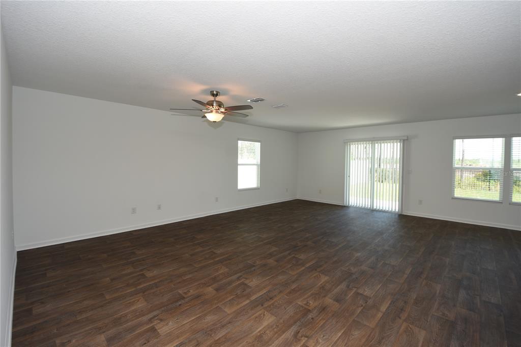 9 Springwood Drive Palm Coast, FL 32137 - Photo 6 of 29 an empty room with wooden floor and windows