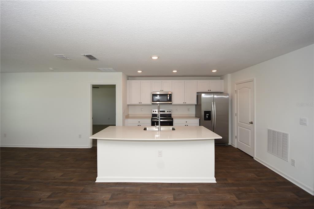 9 Springwood Drive Palm Coast, FL 32137 - Photo 9 of 29 a kitchen with kitchen island stainless steel appliances a sink and a refrigerator