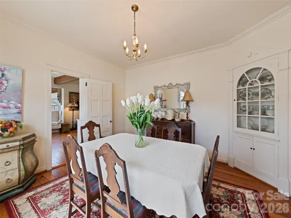 a view of a dining room with furniture a chandelier and wooden floor
