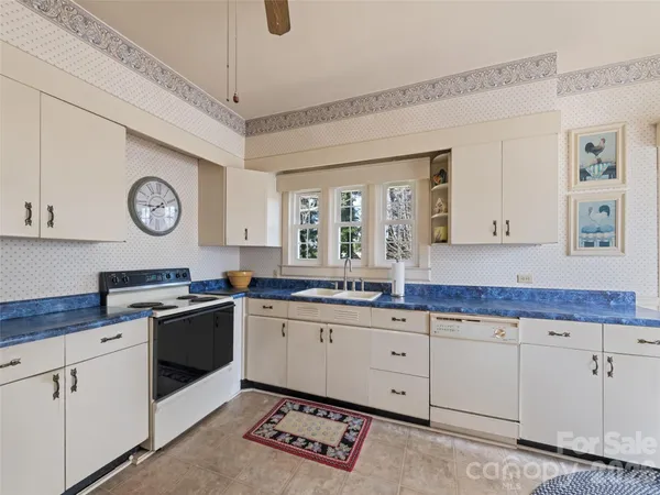 a kitchen with a refrigerator a stove top oven and cabinets