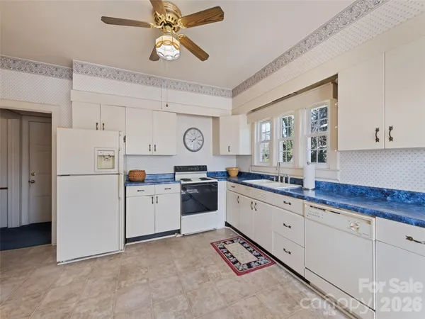 a large kitchen with kitchen island granite countertop a table chairs sink and cabinets