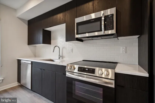 a kitchen with a sink and steel appliances