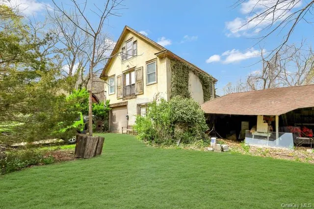 a view of a house with backyard and sitting area