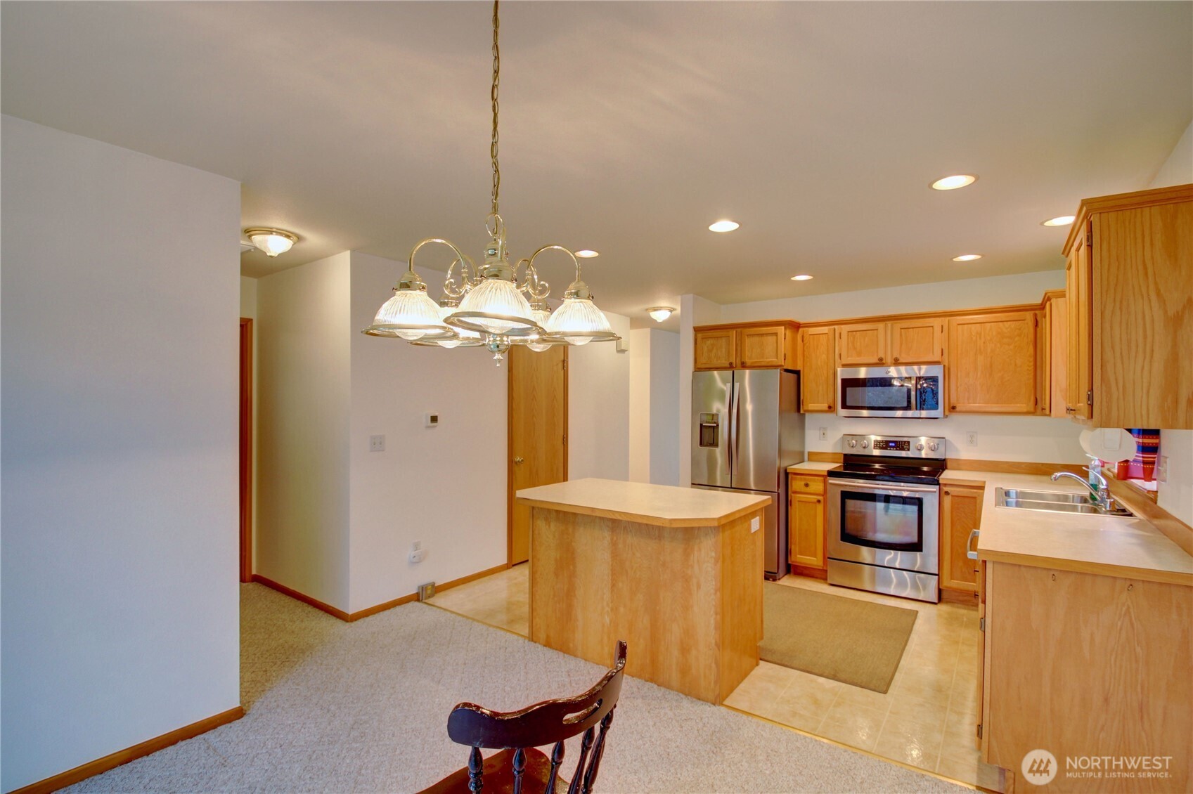 1072 Sinclair Way, Unit 56 Burlington, WA 98233 - Photo 15 of 29 a kitchen with stainless steel appliances granite countertop a refrigerator a stove and a sink with wooden floor