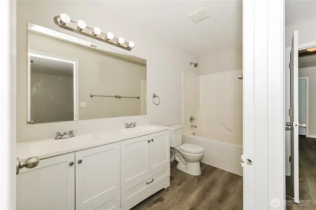 a bathroom with a double vanity sink mirror and toilet