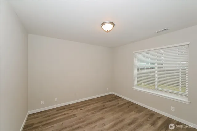 a view of a room with wooden floor and windows