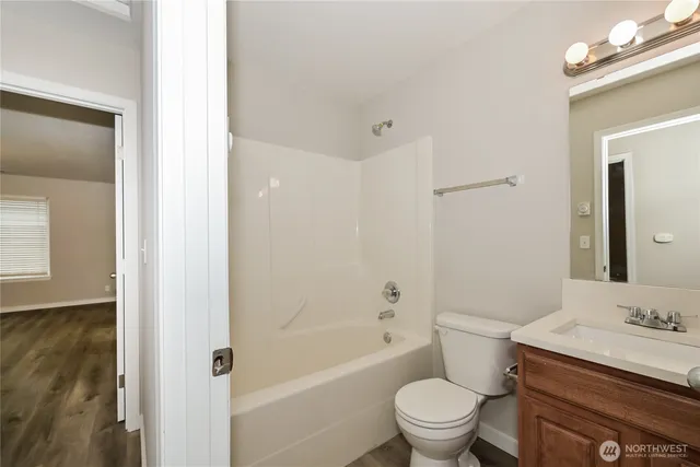 a bathroom with a granite countertop toilet a sink and a bathtub