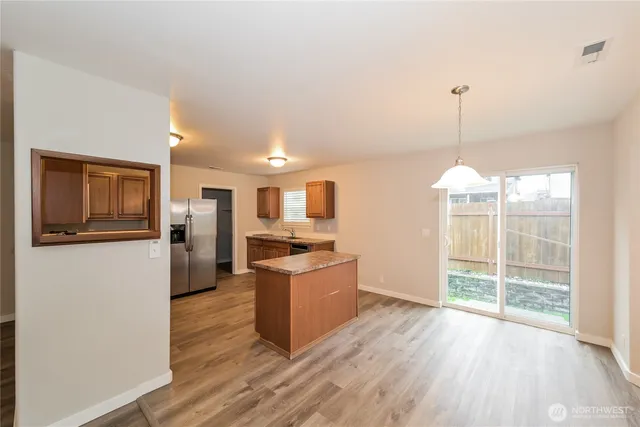 a open kitchen with refrigerator stove and wooden floor
