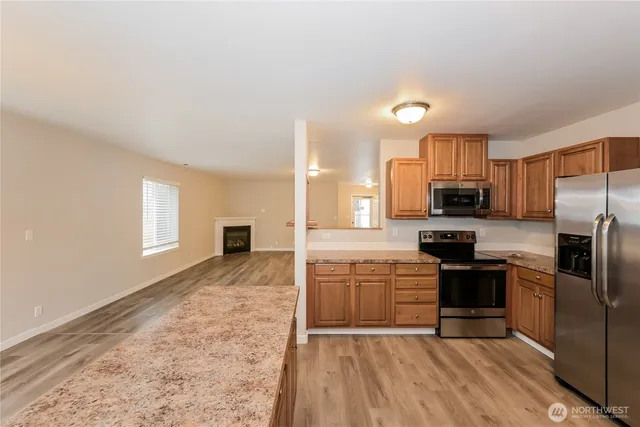 a kitchen with stainless steel appliances granite countertop a refrigerator a stove top oven a sink and dishwasher