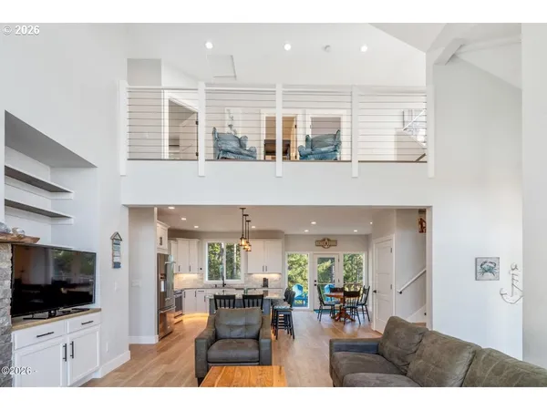 a living room with stainless steel appliances kitchen island granite countertop a table and chairs in it