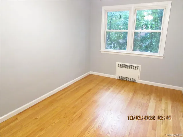 a view of a room with wooden floor and a window