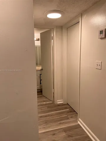 a view of a hallway with wooden floor