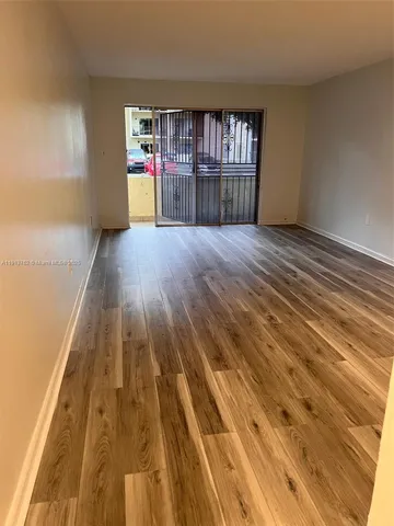 a room with wooden floor and book shelf