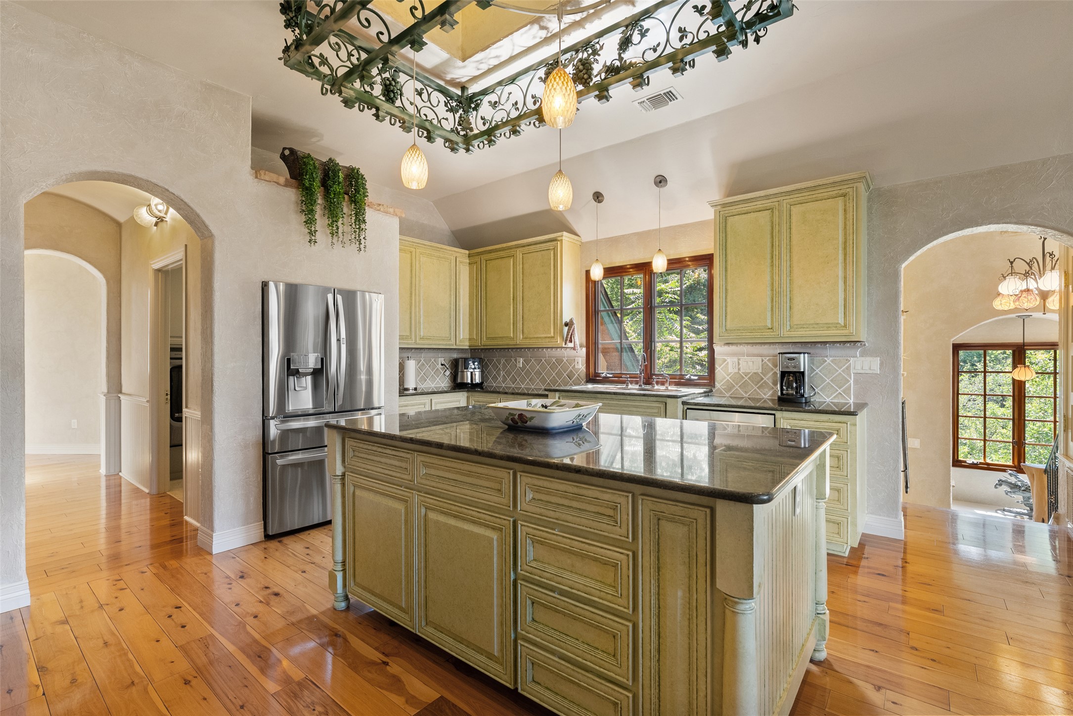 1354 The High Road Austin, TX 78746 - Photo 17 of 40 A well-appointed kitchen showcasing a central island and rich wooden floors.