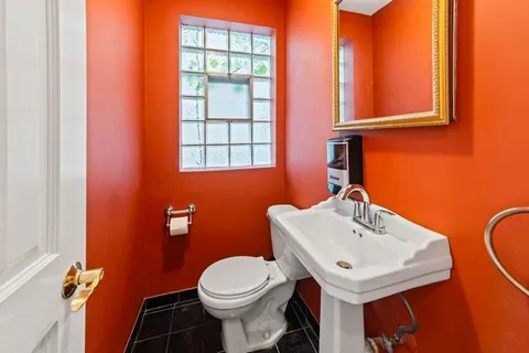 a bathroom with a sink a toilet and a mirror