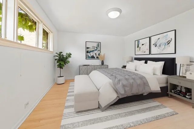 a spacious bedroom with a large bed and a potted plant