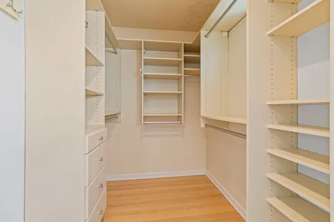 a view of walk in closet with empty racks