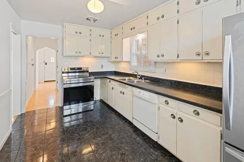 a kitchen with stainless steel appliances granite countertop a stove a sink and a refrigerator