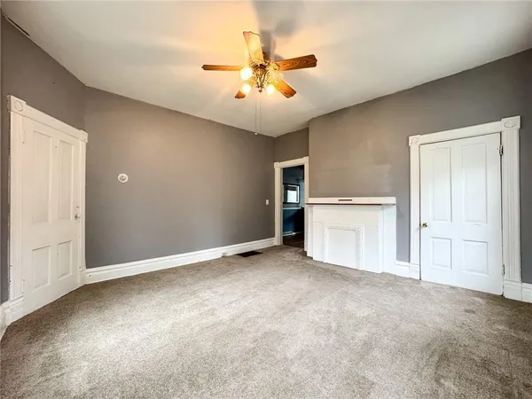 a view of an empty room with a ceiling fan