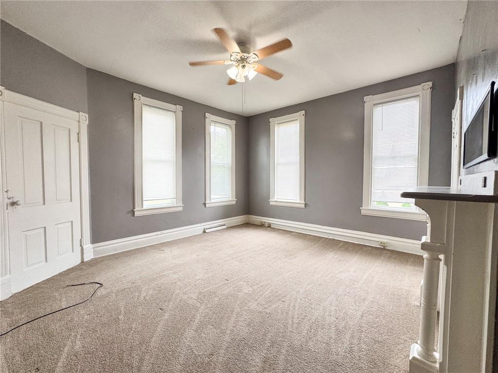 411 Cherry Street, Unit 1 Butler, PA 16001 - Photo 12 of 16 an empty room with windows and ceiling fan