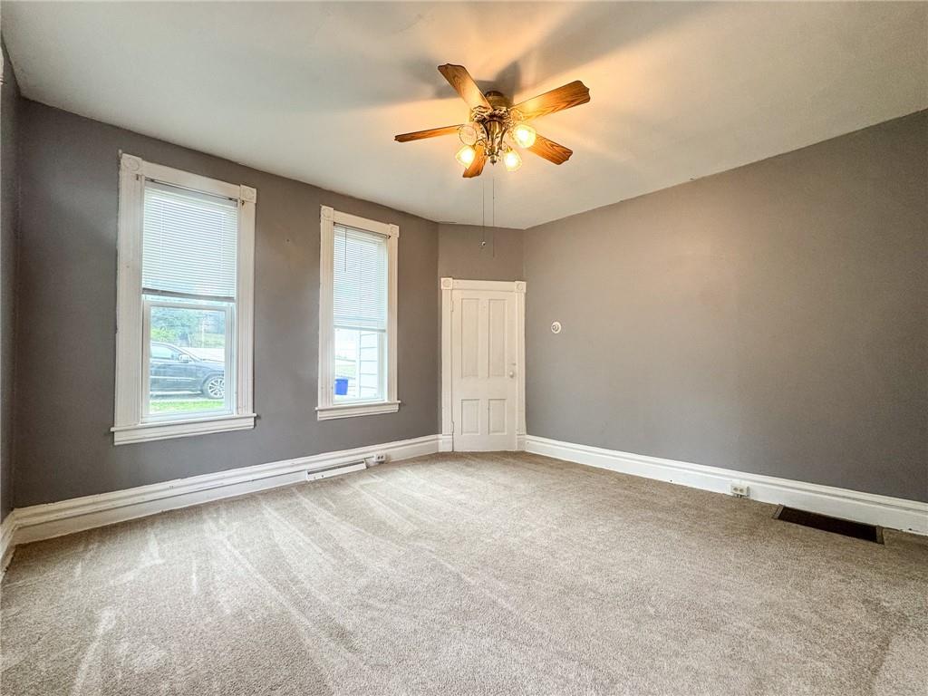 411 Cherry Street, Unit 1 Butler, PA 16001 - Photo 10 of 16 an empty room with window and ceiling fan