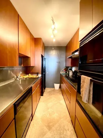 a kitchen with stainless steel appliances kitchen island granite countertop a stove and a sink