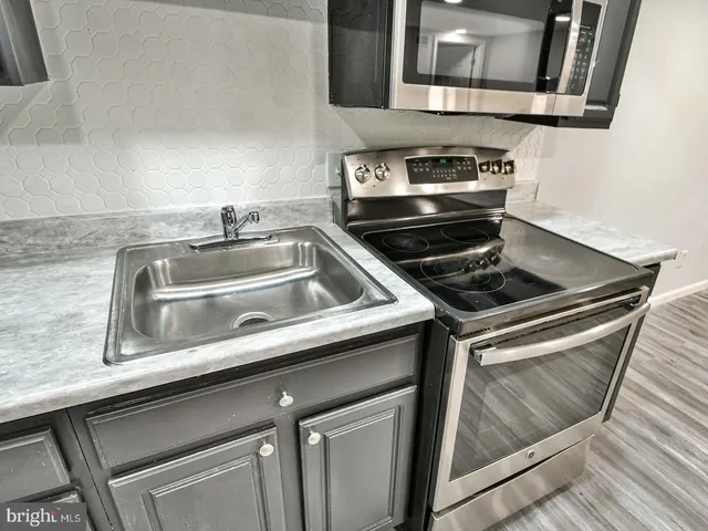 a kitchen with stainless steel appliances kitchen island granite countertop a refrigerator and a stove top oven