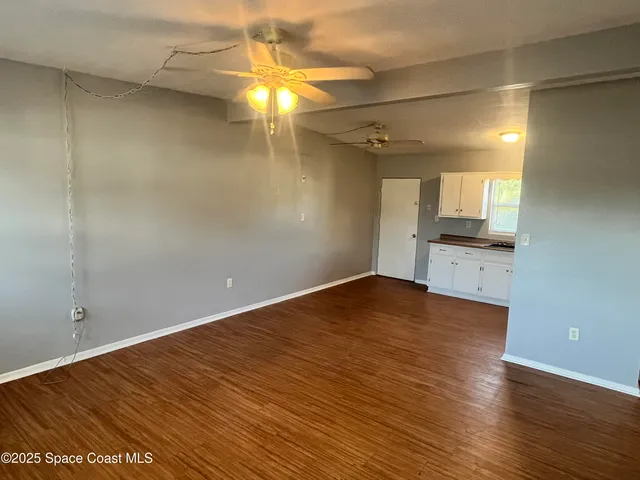 an empty room with wooden floor and door