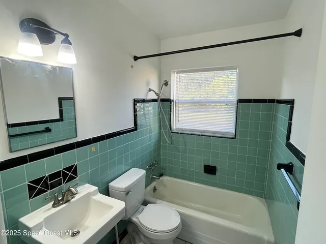 a bathroom with a sink mirror toilet and bathtub