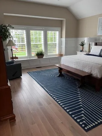 a bedroom with a bed and a large window