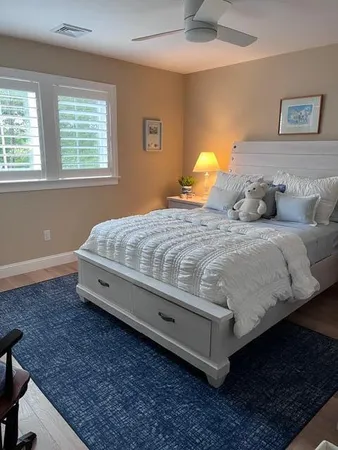 a bedroom with a bed and a lamp on the dresser
