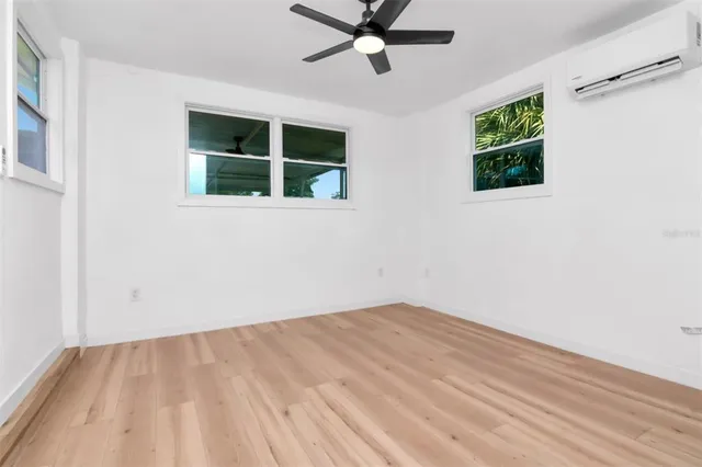 a view of empty room with window and ceiling fan